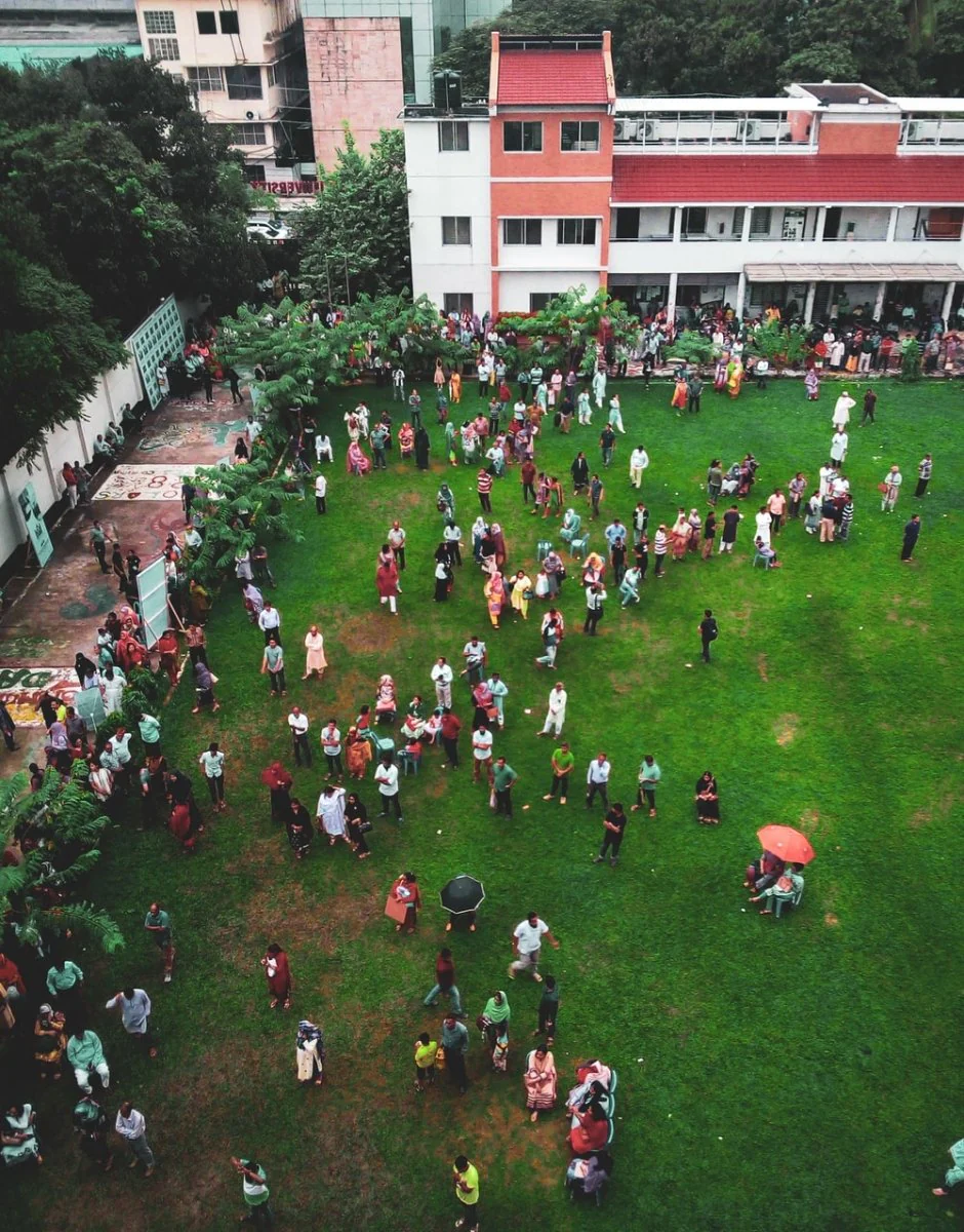 Paint By Numbers | Dhaka - Aerial Photography Of People Walking On Green Field Near White And Red Concrete 3-Story Building During Daytime