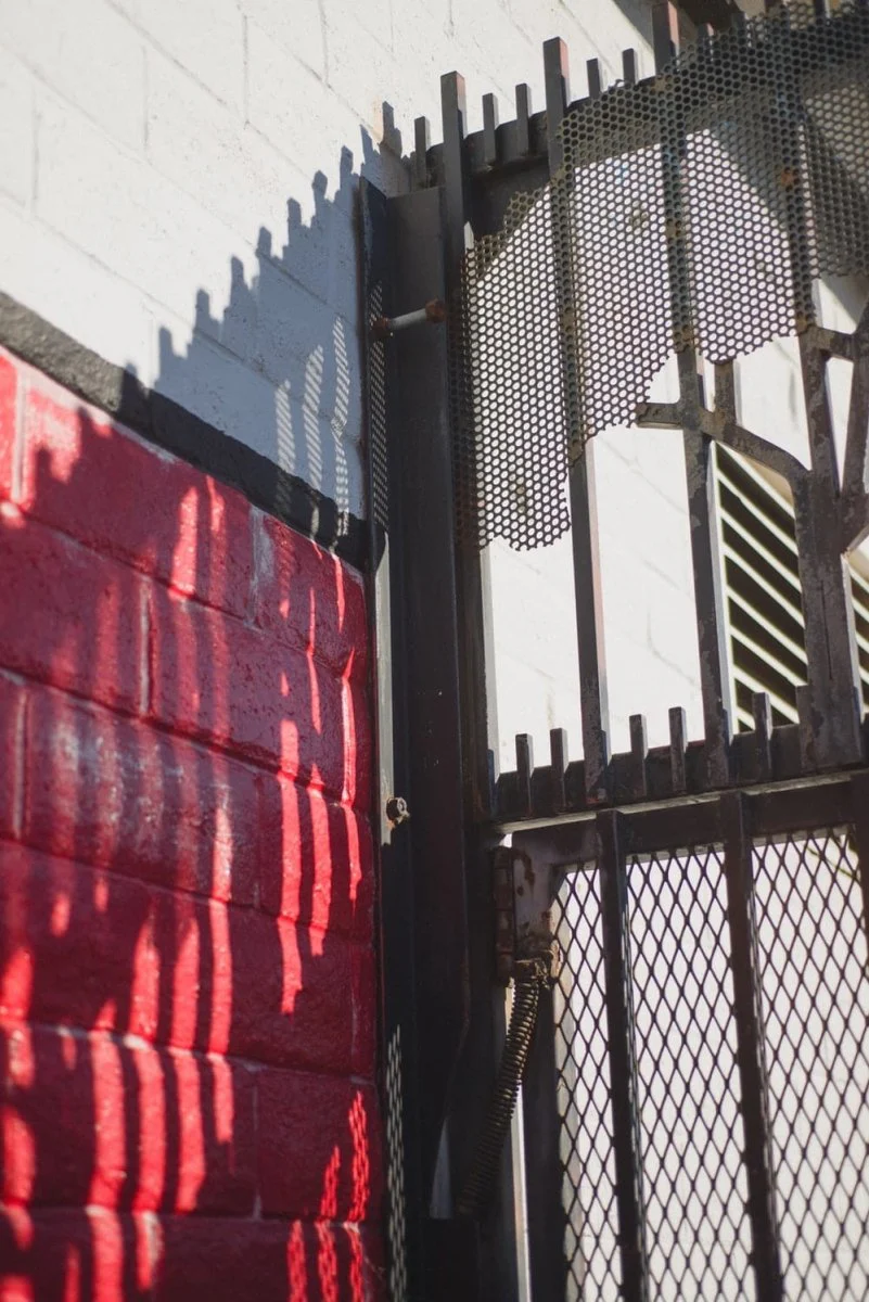Paint By Numbers | Santa Cruz - Black Metal Fence Near Red And White Concrete Building During Daytime