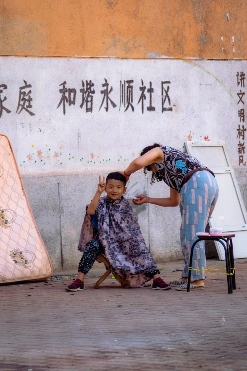 Paint By Numbers | Dalian - Boy Sitting On Stool Beside Standing Woman Near Wall
