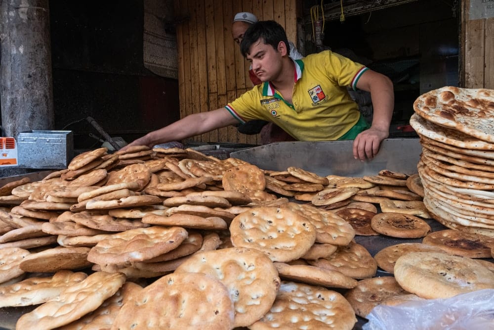 Paint By Numbers | Ürümqi - Man In Green And Yellow Polo Shirt Holding Brown Bread