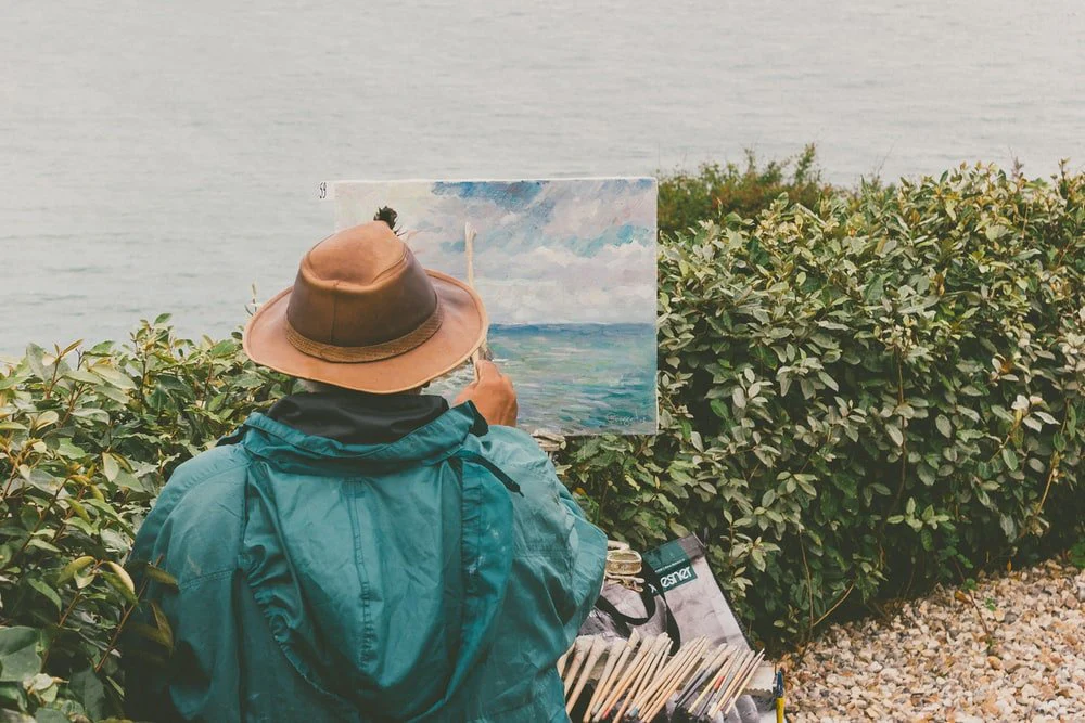 Paint By Numbers | Man Painting Body Of Water In Front Of Bushes
