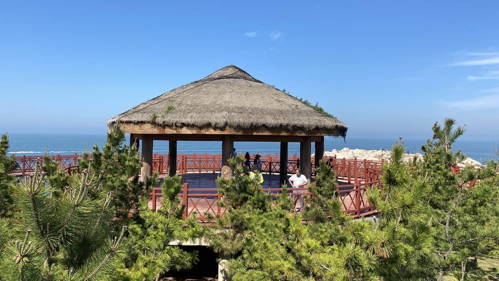 Paint By Numbers | Yantai - People Sitting On Brown Wooden Chairs Near Brown Wooden House Under Blue Sky During Daytime