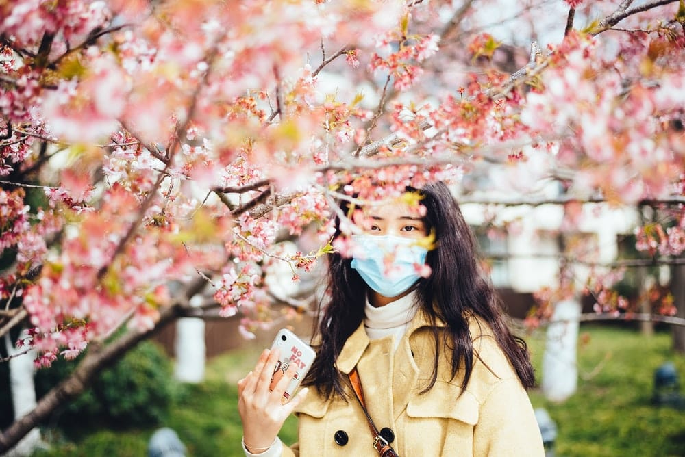 Paint By Numbers | Yangzhou - Woman In Brown Coat With Blue And White Face Mask Holding White Smartphone